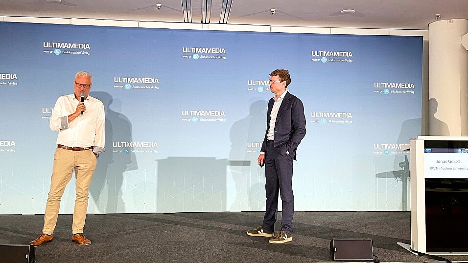 Speaker Jonas Gorsch on stage talking with chairman Peter Gresch after his talk about BYD vs. Tesla - Cell Tech Benchmark at The Automotive Battery – Key Technology for Electric Vehicles 9th - 10th July 2025